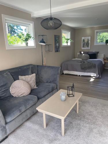 uma sala de estar com um sofá e uma cama em Hallonet em Alingsås