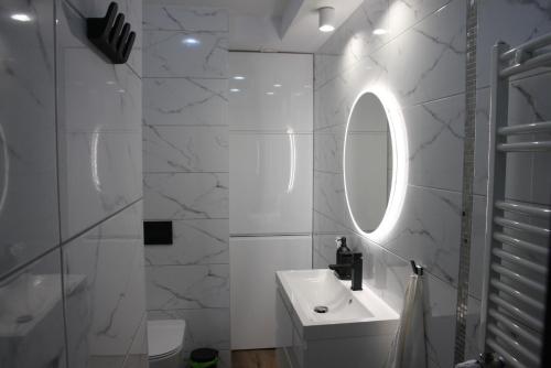 a white bathroom with a sink and a mirror at NAD LISIM JAREM in Jastrzębia Góra