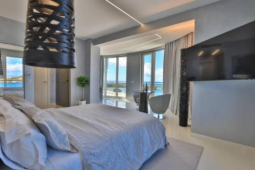 a bedroom with a large bed and large windows at Serenity Penthouse - The Pinnacle of Luxury in Maho Reef