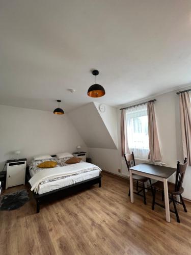 a bedroom with a bed and a table in it at Resort LUFT Sněžník in Sněžnik