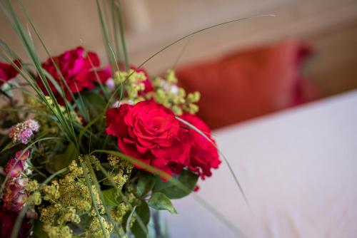 a bouquet of red roses in a vase at Hotel Finkennest - Panoramic Garden Resort in Schenna