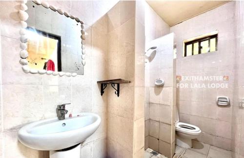 La salle de bains est pourvue d'un lavabo et de toilettes. dans l'établissement Lala lodge Pemba Zanzibar, à Mgini