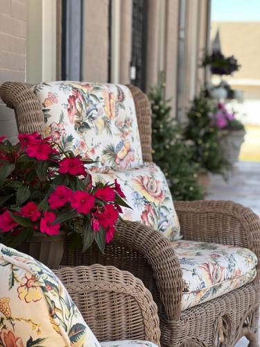 a wicker chair with a floral pillow and flowers at THE CW HOUSE in Claude