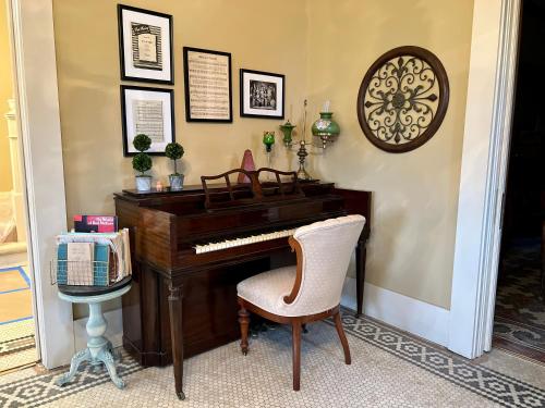 a piano and a chair in a room at THE CW HOUSE in Claude
