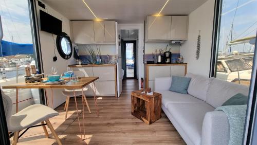 uma sala de estar e cozinha com um sofá e uma mesa em Hausboot Aava em Schleswig