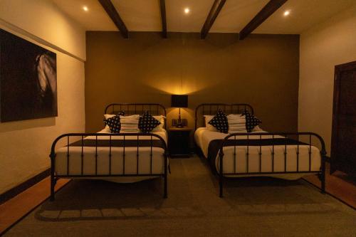a room with two beds and a lamp in it at Hacienda El Salitre Hotel & Spa in Querétaro