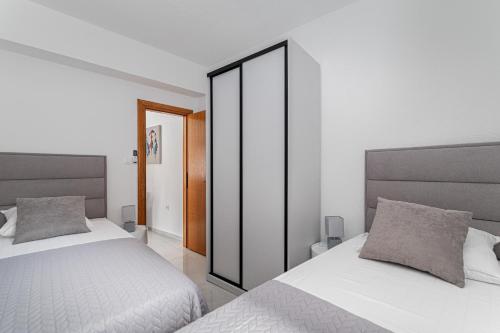 a bedroom with two beds and a large mirror at Holiday Home Quadro Rabac in Rabac