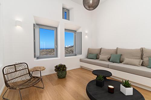 a living room with a couch and two windows at Cape Ftelia in Elia