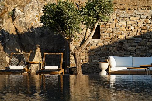 a pool of water with two chairs and a tree at Cape Ftelia in Elia