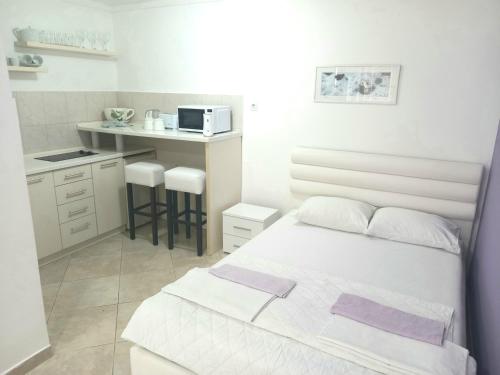1 dormitorio blanco con 1 cama y cocina en Apartments Kotor Sunrise, en Kotor