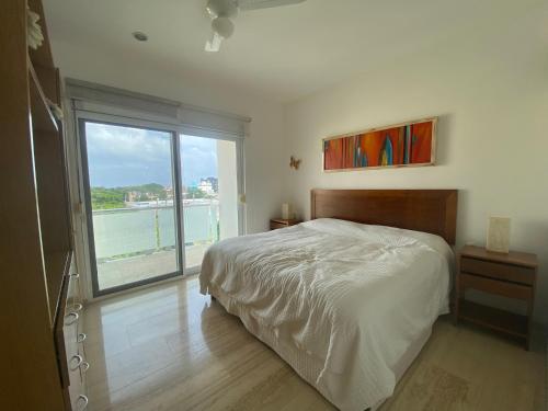 a bedroom with a bed and a large window at Prime 1 Bedroom Condo in Historic Downtown Playa del Carmen in Playa del Carmen