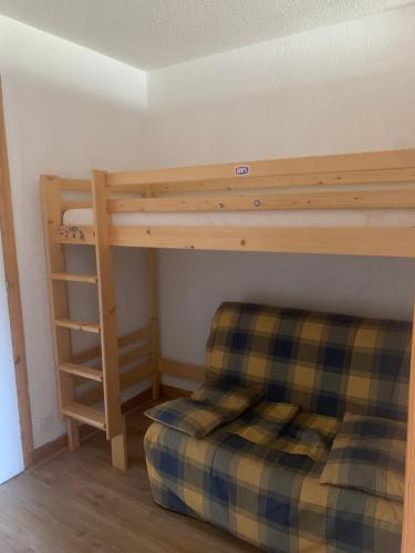 a bedroom with a bunk bed and a couch at Appartement avec accès piscine- Station- 4 personnes in Saint-Jean-dʼAulps