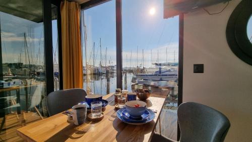 a table with chairs and a view of a marina at Hausboot Hilja - neuer Ankerplatz! in Schleswig