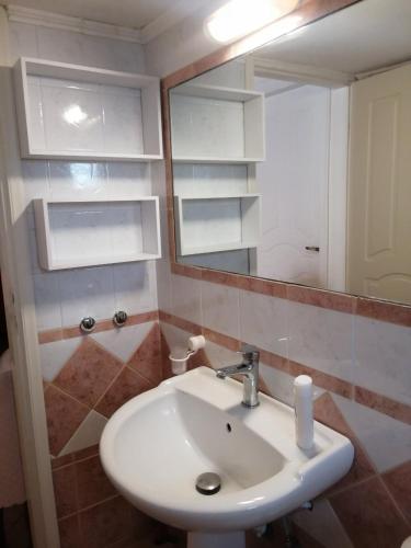 a bathroom with a white sink and a mirror at Olive Tree House I in Dhermatiánika