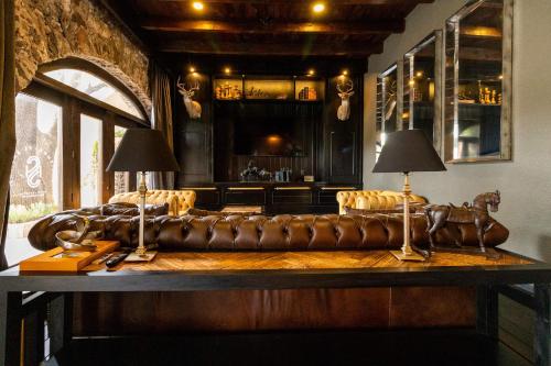 salon ze skórzaną kanapą i barem w obiekcie Hacienda El Salitre Hotel & Spa w mieście Querétaro