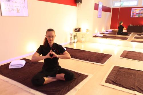 a woman sitting on the floor in a yoga class at Pension Amo Marem in Dierhagen