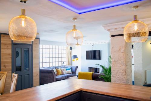 a living room with two pendant lights over a bar at Cosy Open Plan Harbourside Inn with SuperKing Beds, Wood Burning Stove and Bar in Torquay