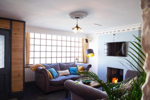 sala de estar con sofá y chimenea en Cosy Open Plan Harbourside Inn with SuperKing Beds, Wood Burning Stove and Bar, en Torquay