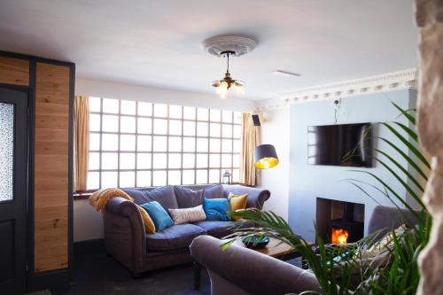a living room with a couch and a fireplace at Cosy Open Plan Harbourside Inn with SuperKing Beds, Wood Burning Stove and Bar in Torquay