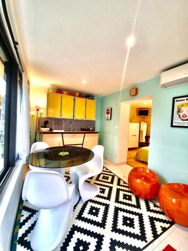 Cette chambre comprend une table et des chaises blanches. dans l'établissement La Maison Pop Appartement meublé indépendant avec jardin, à Romans-sur-Isère