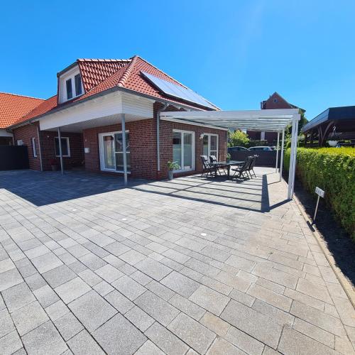 a patio in front of a house with a roof at Haus Hobbingshof Greetsiel in Greetsiel