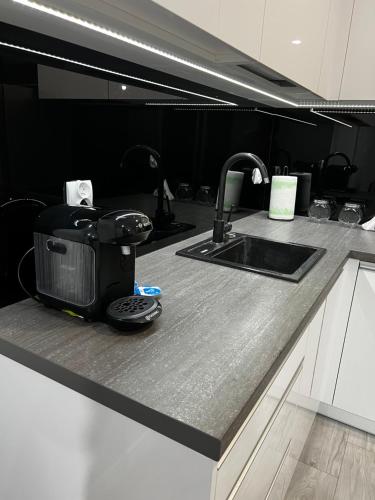 a kitchen counter with a toaster and a sink at Apartment Comfort in Bartoszyce