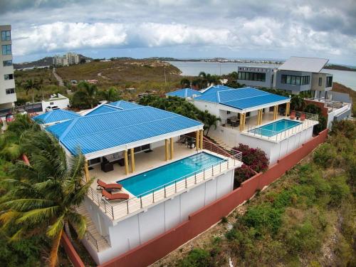 an aerial view of a house with blue roofs at Airport View 3-Bed Villa in Cupecoy