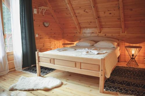 Un dormitorio con una cama en una cabaña de madera. en Holiday home Aster, en Žabljak