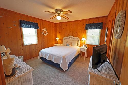 ein Schlafzimmer mit einem Bett und einem Flachbildfernseher in der Unterkunft D116A-The Salty Quacker in Duck