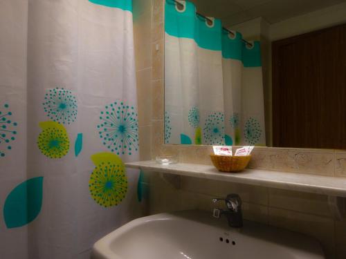 La salle de bains est pourvue d'un lavabo et d'un rideau de douche. dans l'établissement Hotel Azuqueca, à Azuqueca de Henares