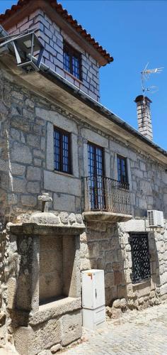 an old stone building with a refrigerator in front of it at Casa do Cruzeiro in Aguiar da Beira