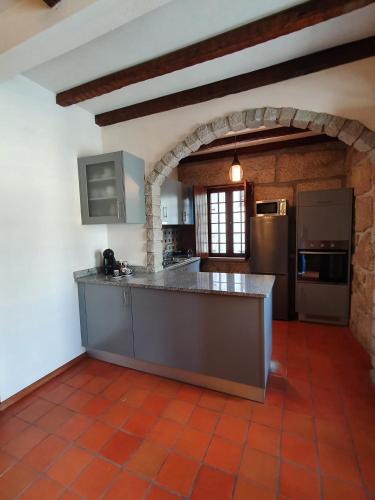 a large kitchen with a large island in a room at Casa do Cruzeiro in Aguiar da Beira