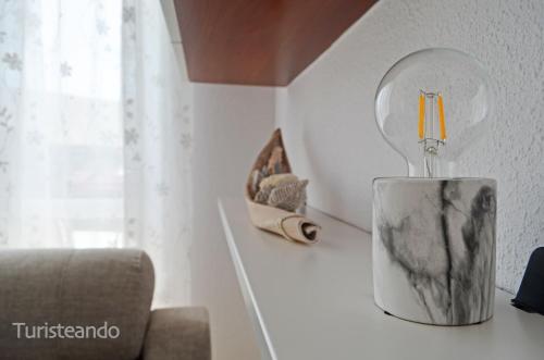 un vaso con una candela su un bancone in una stanza di Viento Norte - Amplia terraza y chill out para quienes buscan descanso y calidez a San Vicente de la Barquera