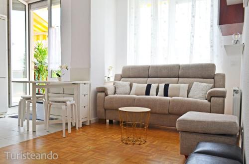 a living room with a couch and a table at Viento Norte - Amplia terraza y chill out para quienes buscan descanso y calidez in San Vicente de la Barquera