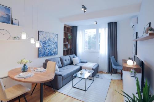 uma sala de estar com um sofá e uma mesa em Arena BIG Luxury Apartments em Novi Sad