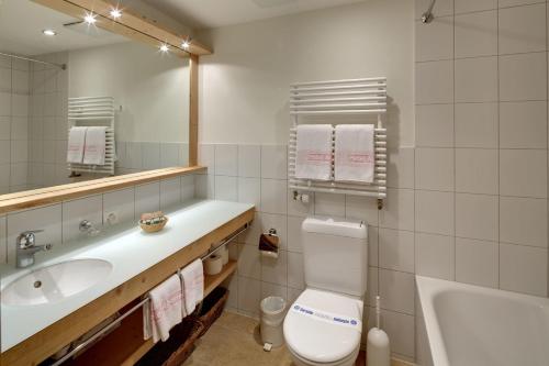 een badkamer met een toilet, een wastafel en een bad bij Hotel Alpenrose Wengen - bringing together tradition and modern comfort in Wengen