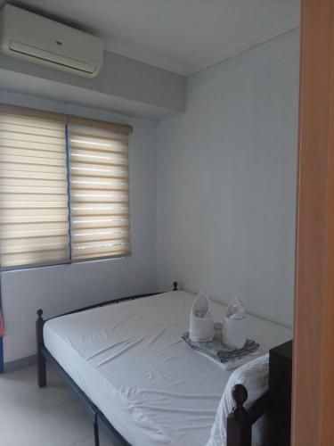 a white bed in a room with a window at Sea res Mall of Asia 2bedroom by Elsie D in Manila