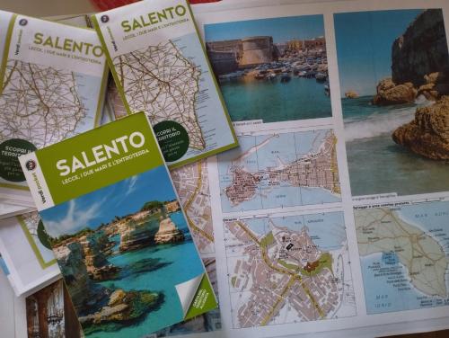 a table topped with maps and pamphlets at Bed&Dreams in Salento - Bilocale deluxe con vasca idromassaggio in Guagnano