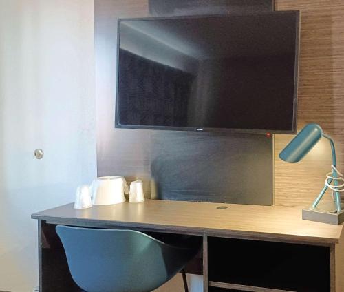 a computer desk with a monitor and a blue chair at Motel 6-Fresno, CA - Blackstone North in Fresno