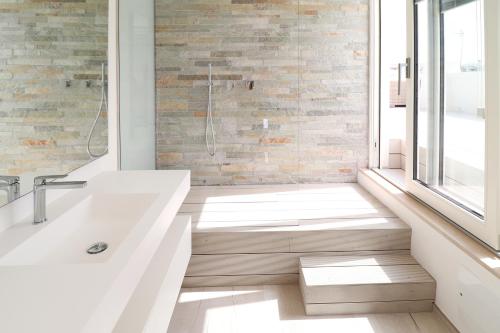 a bathroom with a white tub and a window at IL GELSO BIANCO Luxury apartments in Polignano a Mare