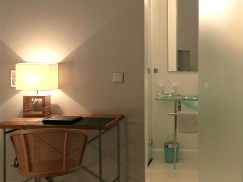 a bathroom with a desk with a lamp and a sink at Hotel Heidelberg Astoria in Heidelberg