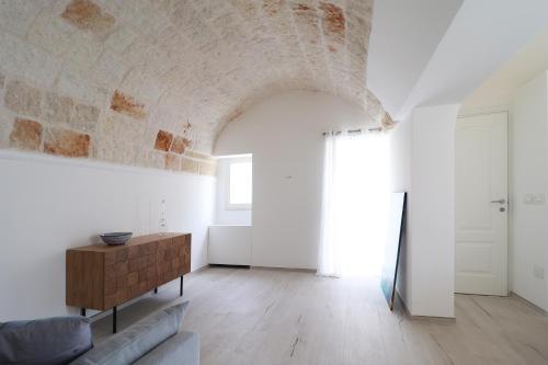 a living room with a couch and a brick wall at IL GELSO BIANCO Luxury apartments in Polignano a Mare