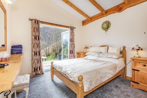 a bedroom with a bed and a window at Druidaig Cottage in Letterfearn