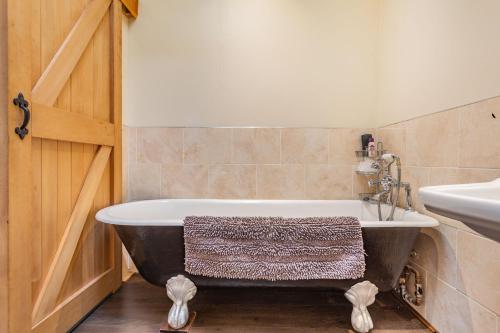 a bathroom with a bath tub and a sink at Druidaig Cottage in Letterfearn