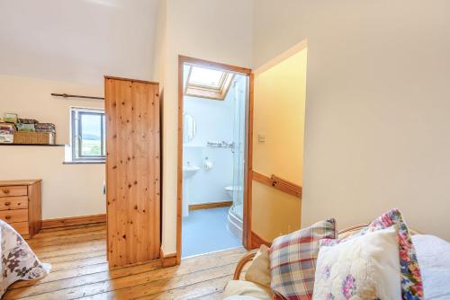 a living room with a door leading to a bathroom at Ystabl - Stable in Llanddulas