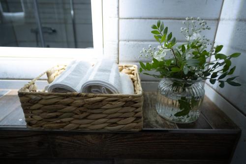 a basket of towels on a table with a vase of flowers at Liptovský mlyn in Bešeňová
