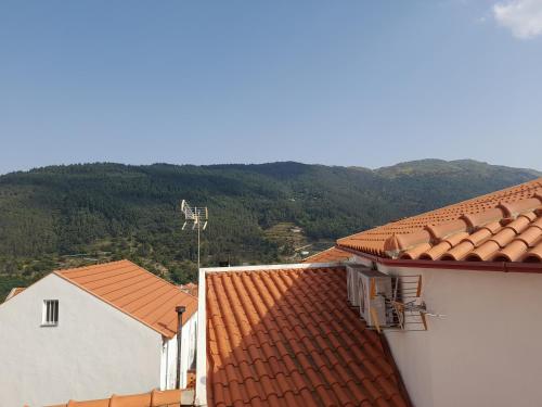 a view of two buildings with mountains in the background at Casa das Neves in Manteigas