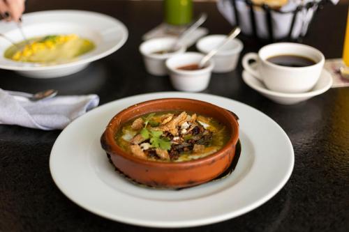 a bowl of food on a plate on a table at Hacienda El Salitre Hotel & Spa in Querétaro