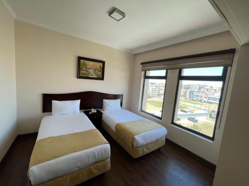 a hotel room with two beds and a window at Rozana Hotel in Amman