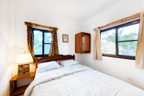 ein weißes Schlafzimmer mit einem Bett und einem Fenster in der Unterkunft Otoch Mayan Falls Gold Standard and Corridor Certified in Caye Caulker